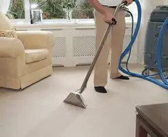 Carpet cleaning professional removing dirt and stains with a hot-water extraction tool in a home, Cincinnati, OH.