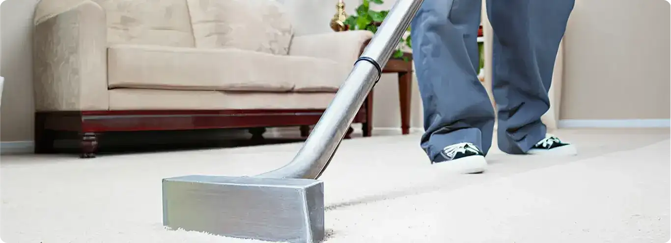 Carpet cleaning technician using a hot-water extraction wand on a light-colored carpet in a living room, Cincinnati, OH.