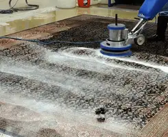 Professional rug cleaning with a rotary floor machine and shampoo foam, deep-cleaning an area rug, in Cincinnati, OH.